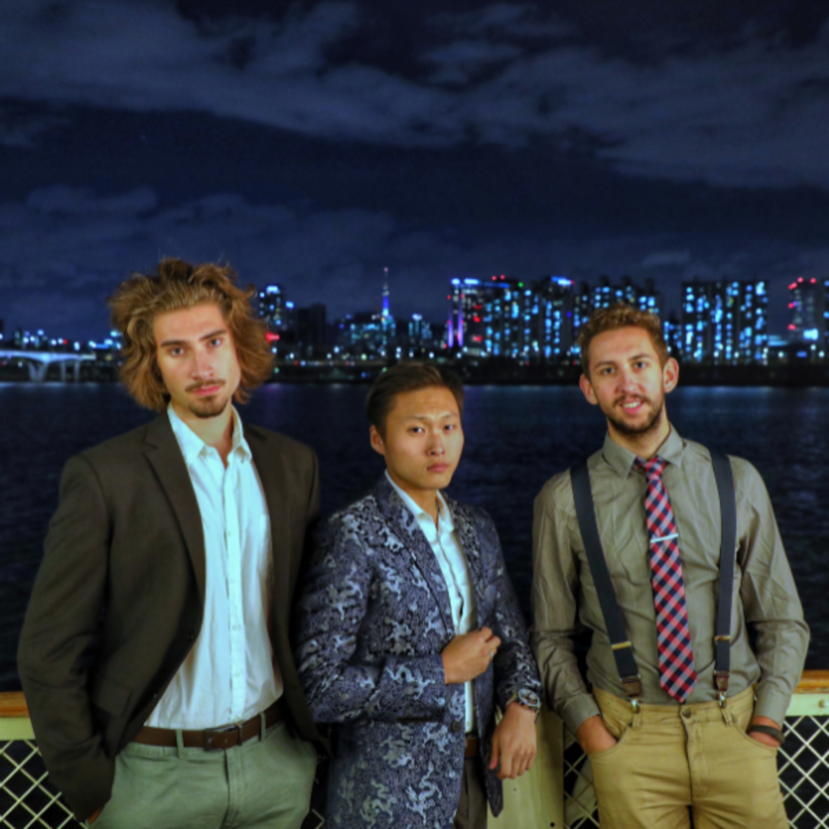 Three students posing in front of the Seoul skyline across the water