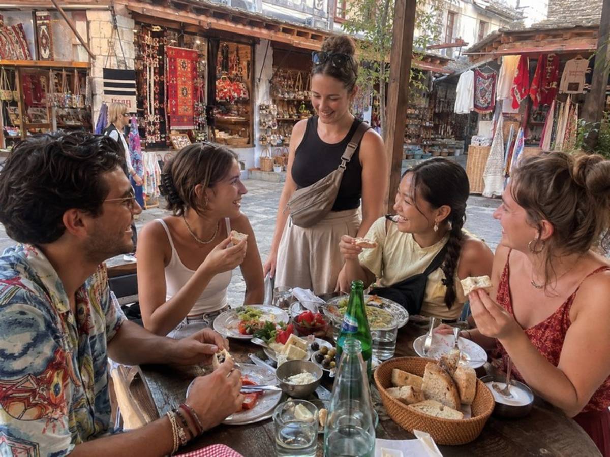 Travellers sharing lunch at a traditional Albanian market