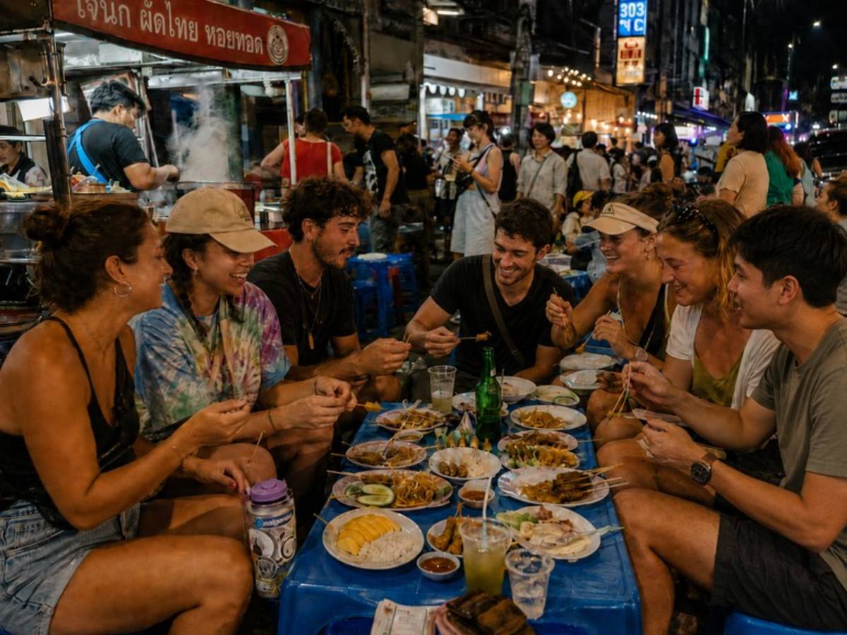Travellers sharing Thai street food at a night market