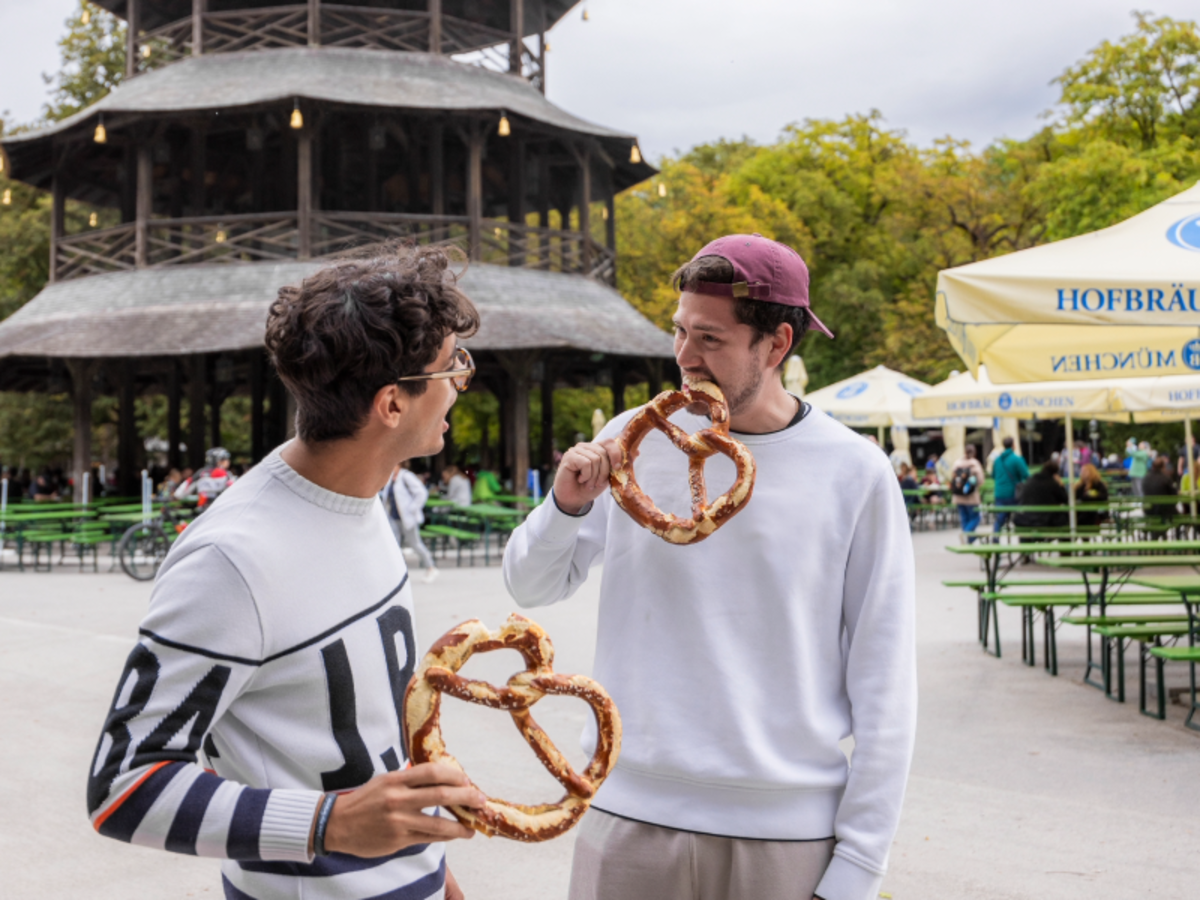 Two EF Munich students enjoy giant pretzels at a traditional beer garden in the city’s English Garden.