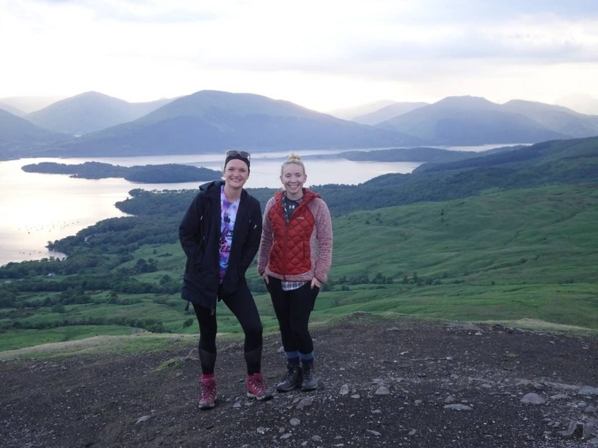 Two of our interns posing in front of a beautiful mountain view in Scotland!