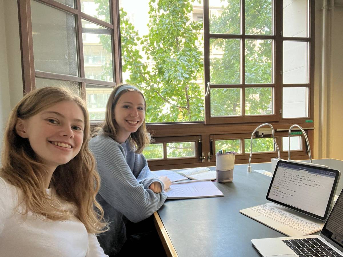 two Students studying at Paris university with notes and laptops