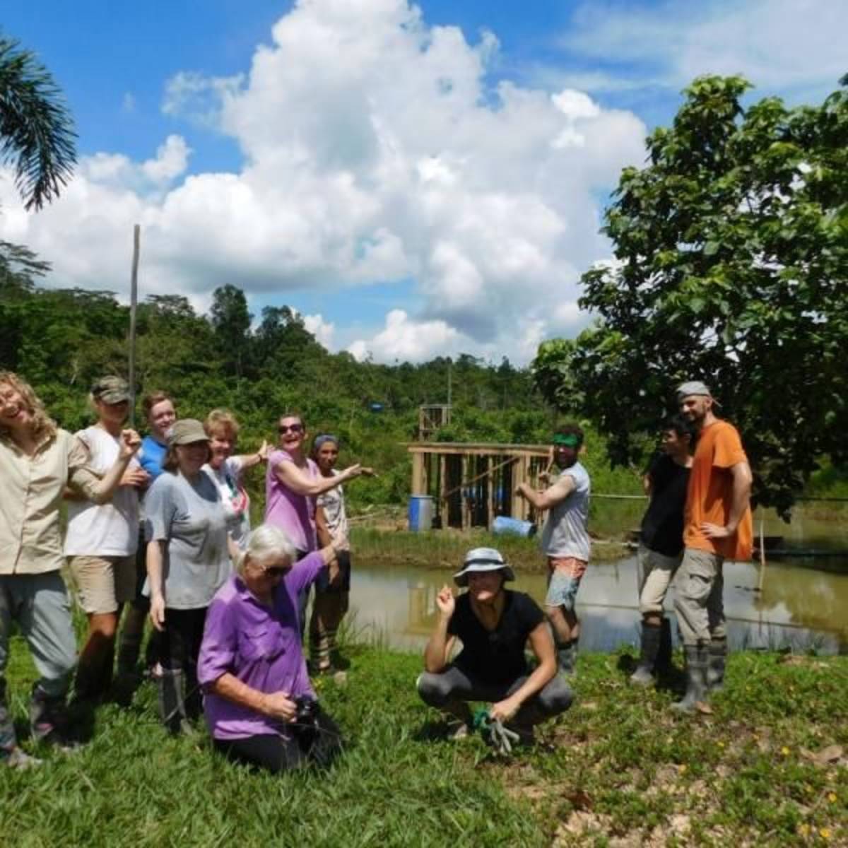 Volunteers posing in front of of a partially-constructed feeding platform for the orangutans