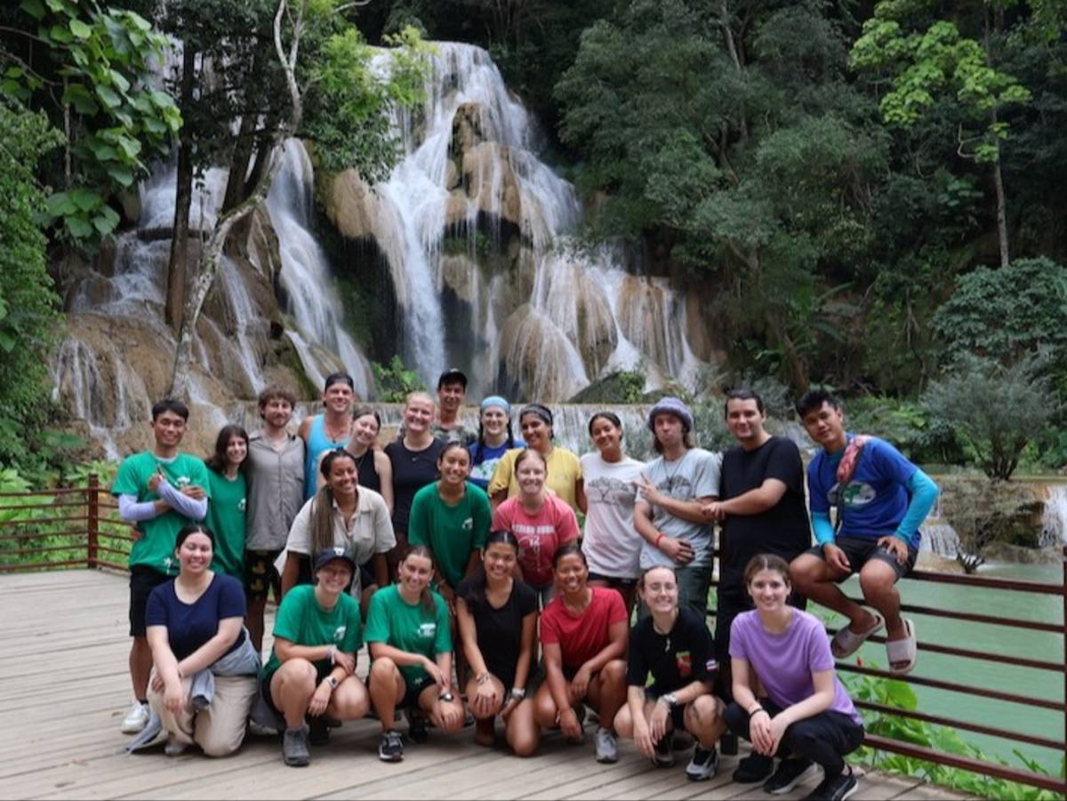 Volunteers in front of waterfall in Laos during excursion