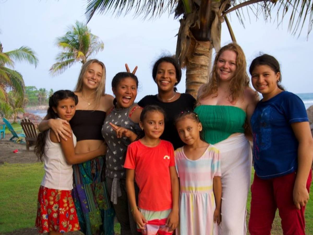 Volunteers with local children on a beach in Nicaragua