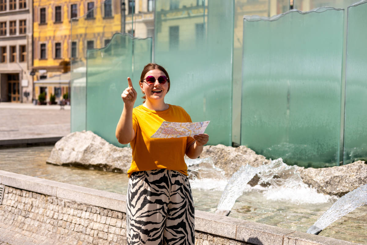 woman pointing somewhere while holding a map