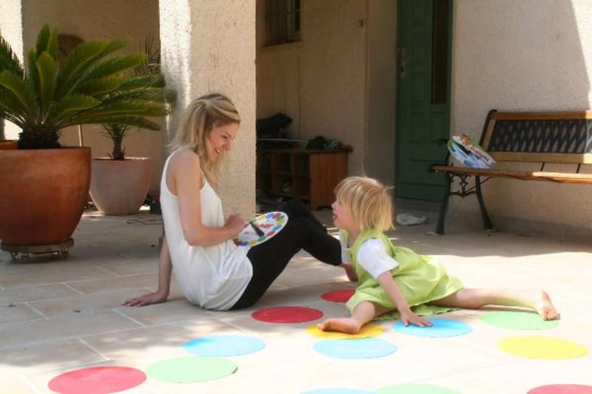A mother playing twister with her daughter