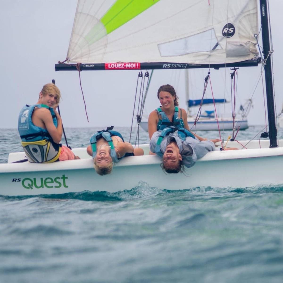 4 teens sailing small boat.