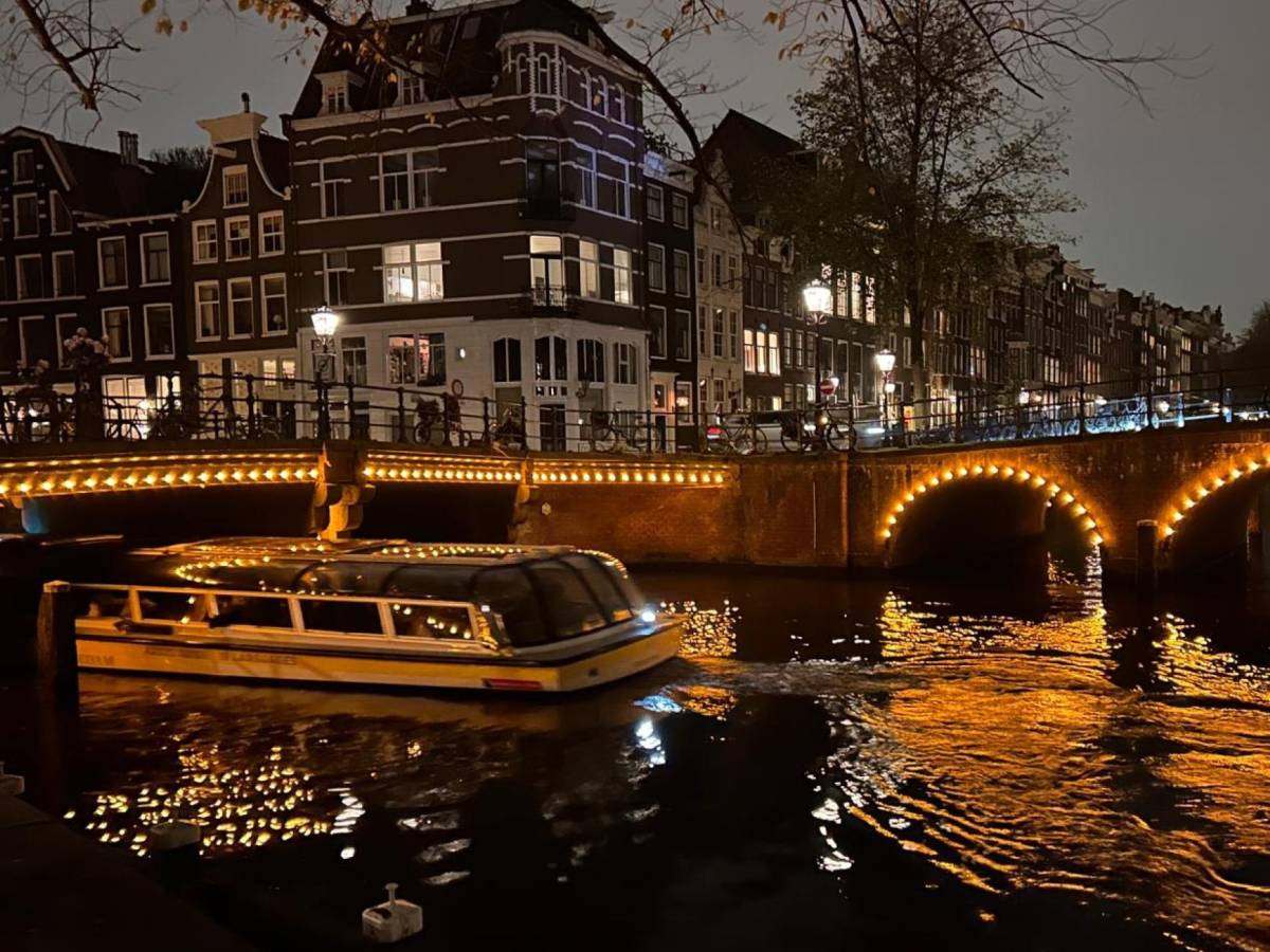 A boat in a canal in Amsterdam at night.