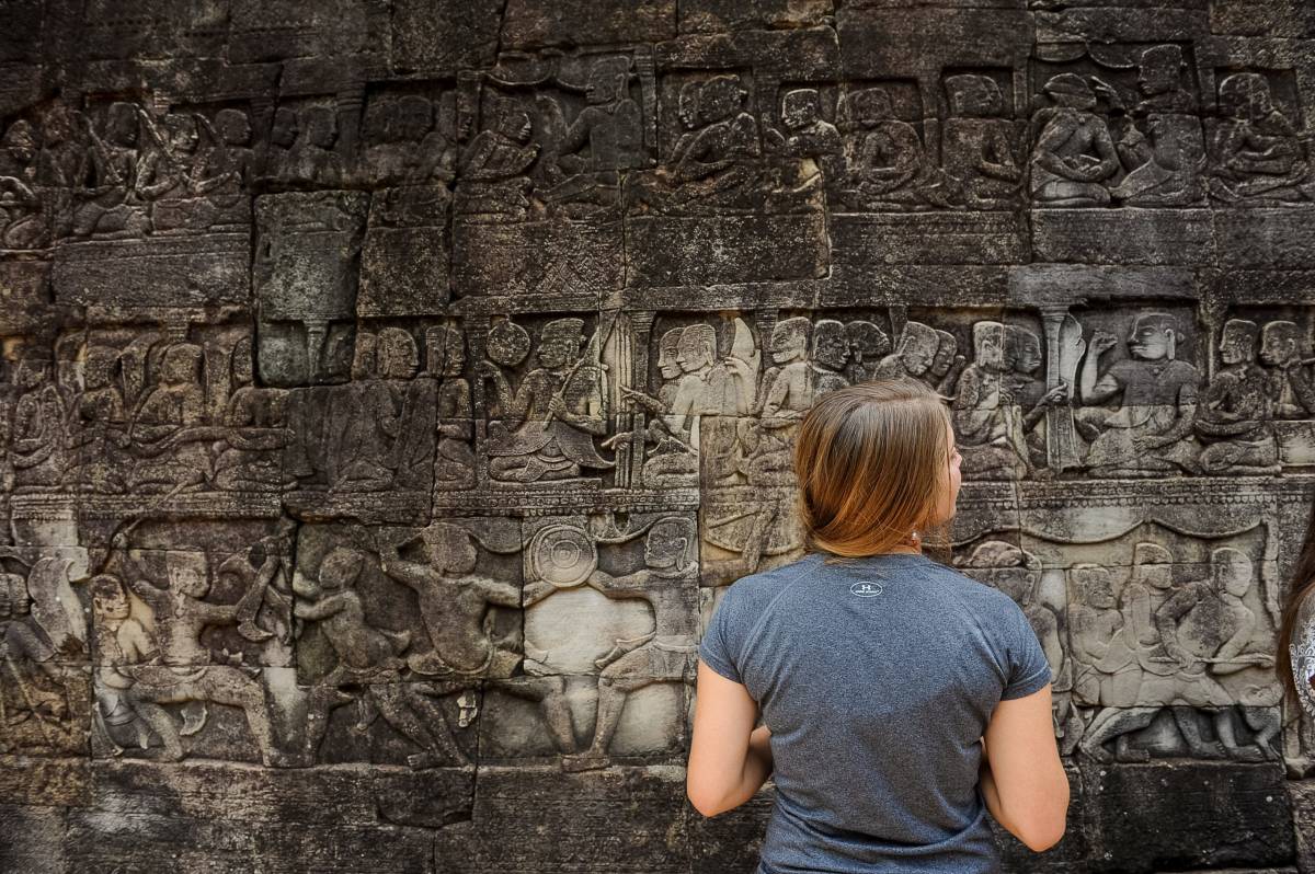 A girl admiring stone carvings in Cambodia