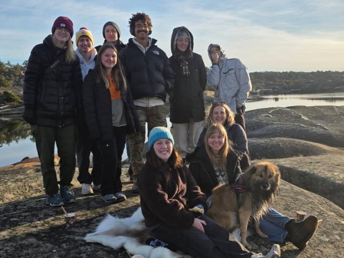 a group of college students pose together smiling while wearing cold weather gear
