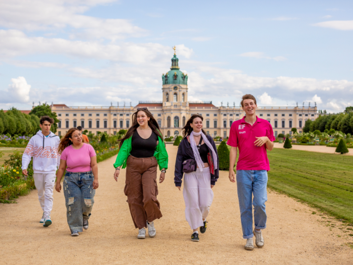 A group of EF students and staff walk together in front of Charlottenburg Palace in Berlin, enjoying a cultural excursion.