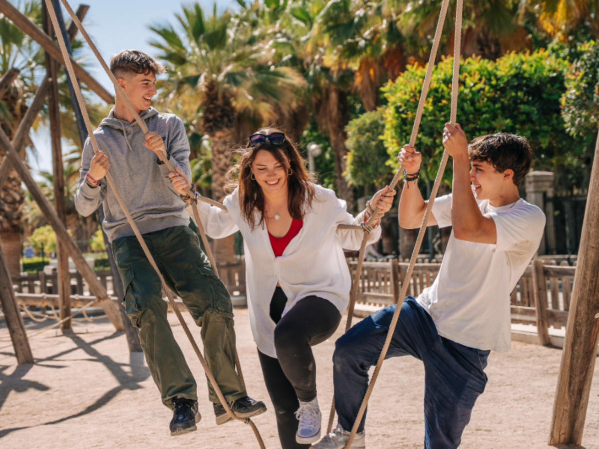A group of EF students sit outdoors on campus in Malaga, smiling and talking together.