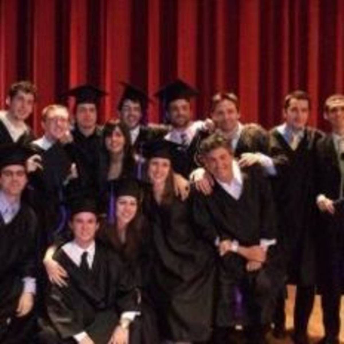 A group of graduates smiling and posing for a photo.