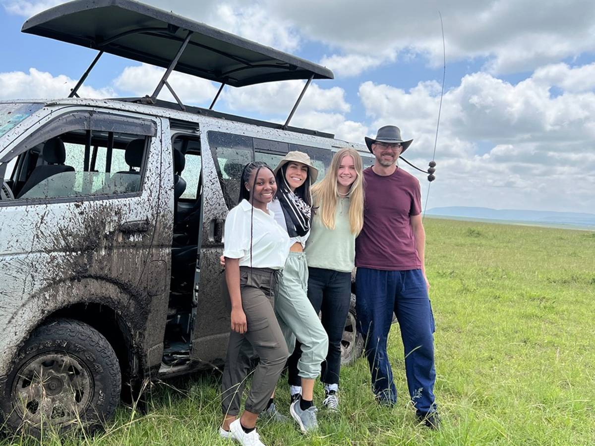 a group of people beside a safari vehicle