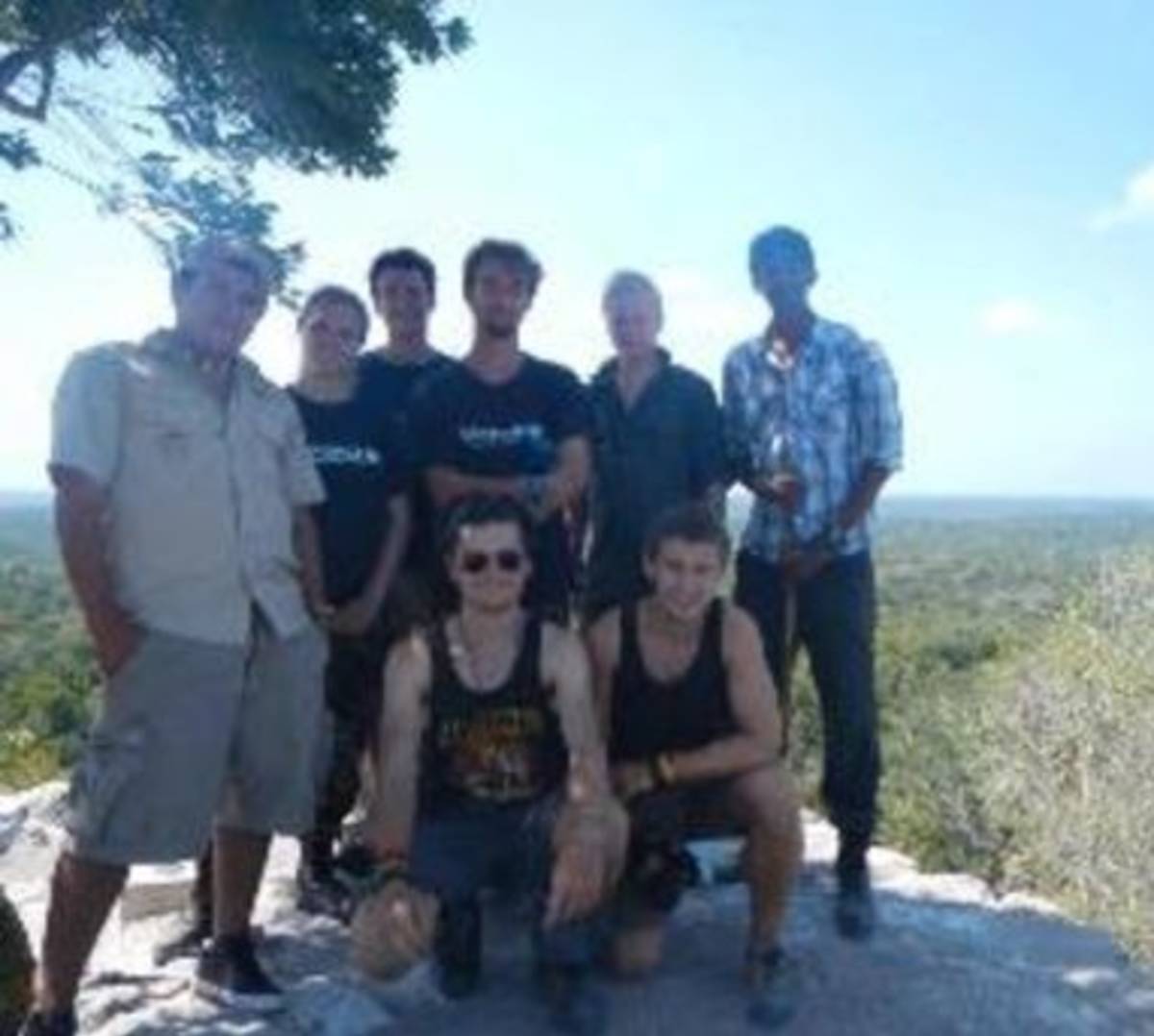 A group of people posing for a photo on a mountain peak.