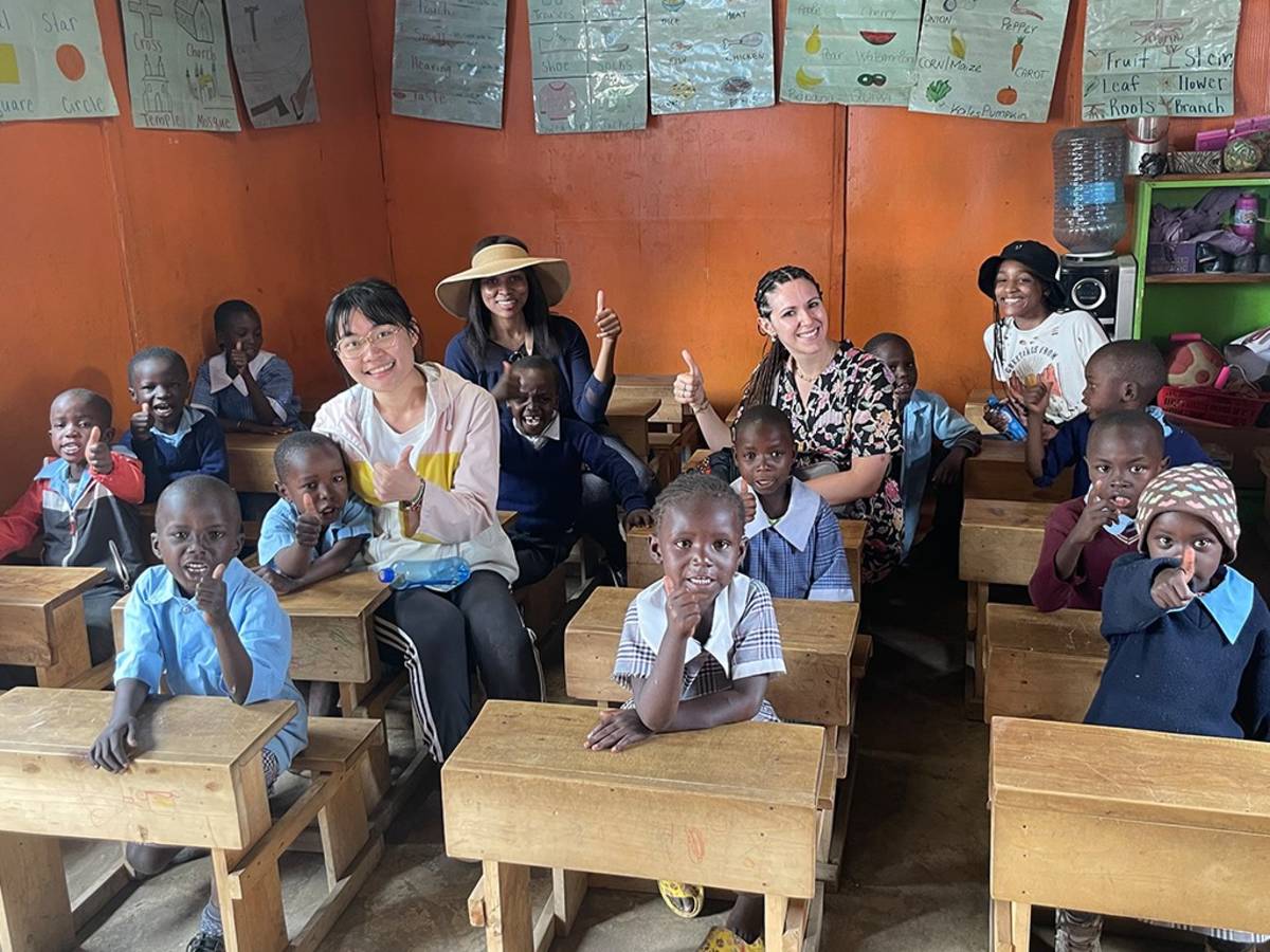 a group of women with local school children
