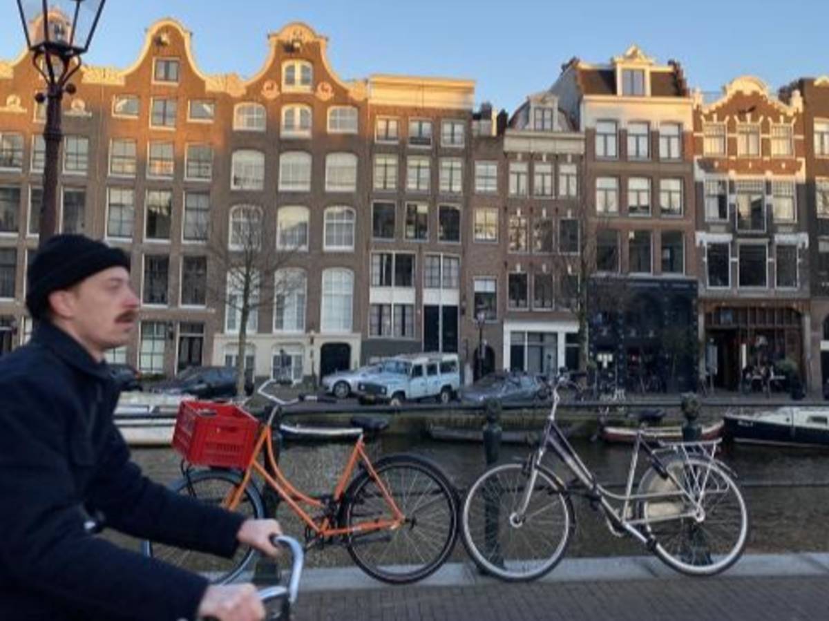 A student bikes next to a canal in Amsterdam.