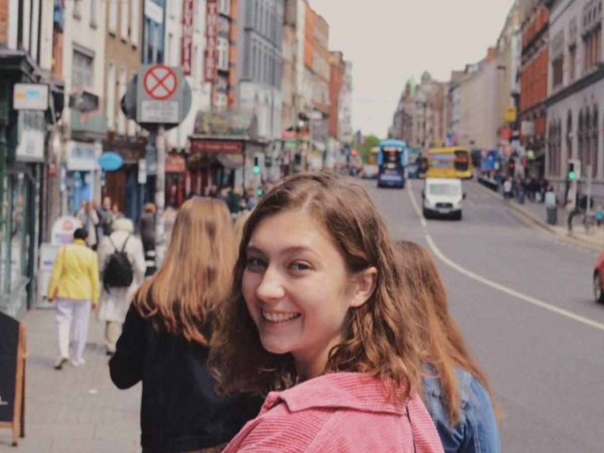 A student in Temple Bar turning around while walking and smiling