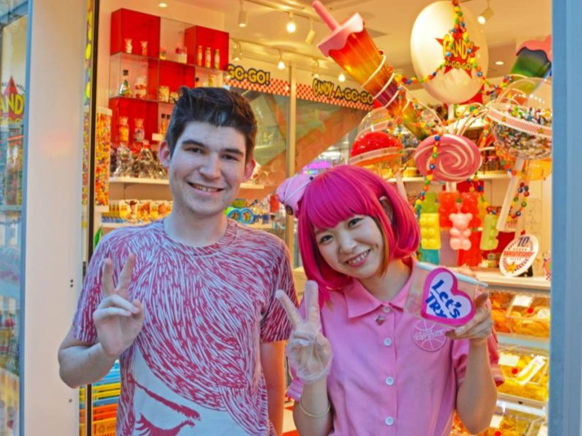 A student poses for a photo with a staff member at a candy store in Harajuku.
