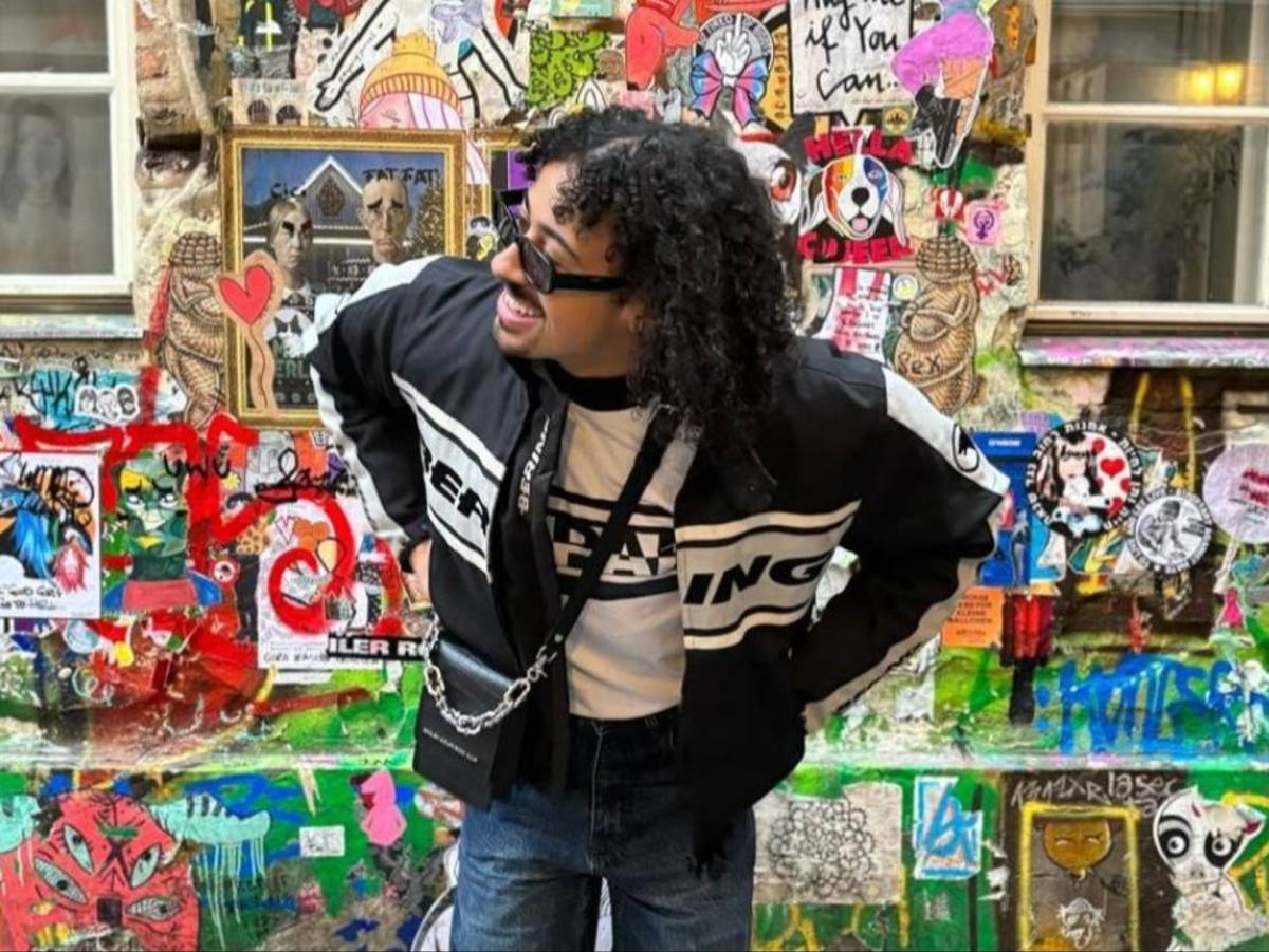 A student poses in front of a brightly colored graffiti wall in Berlin, Germany.