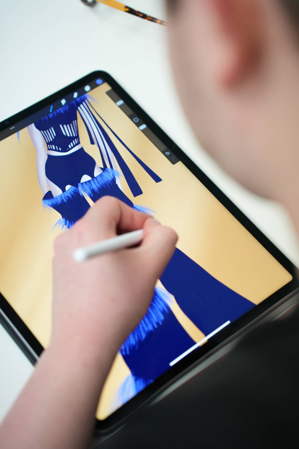 A student using a tablet for fashion design lesson