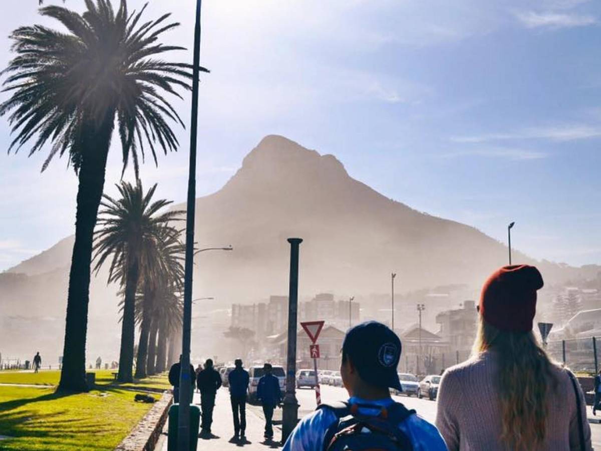 A sunny day where people walk Cape Town's beachside promenade.