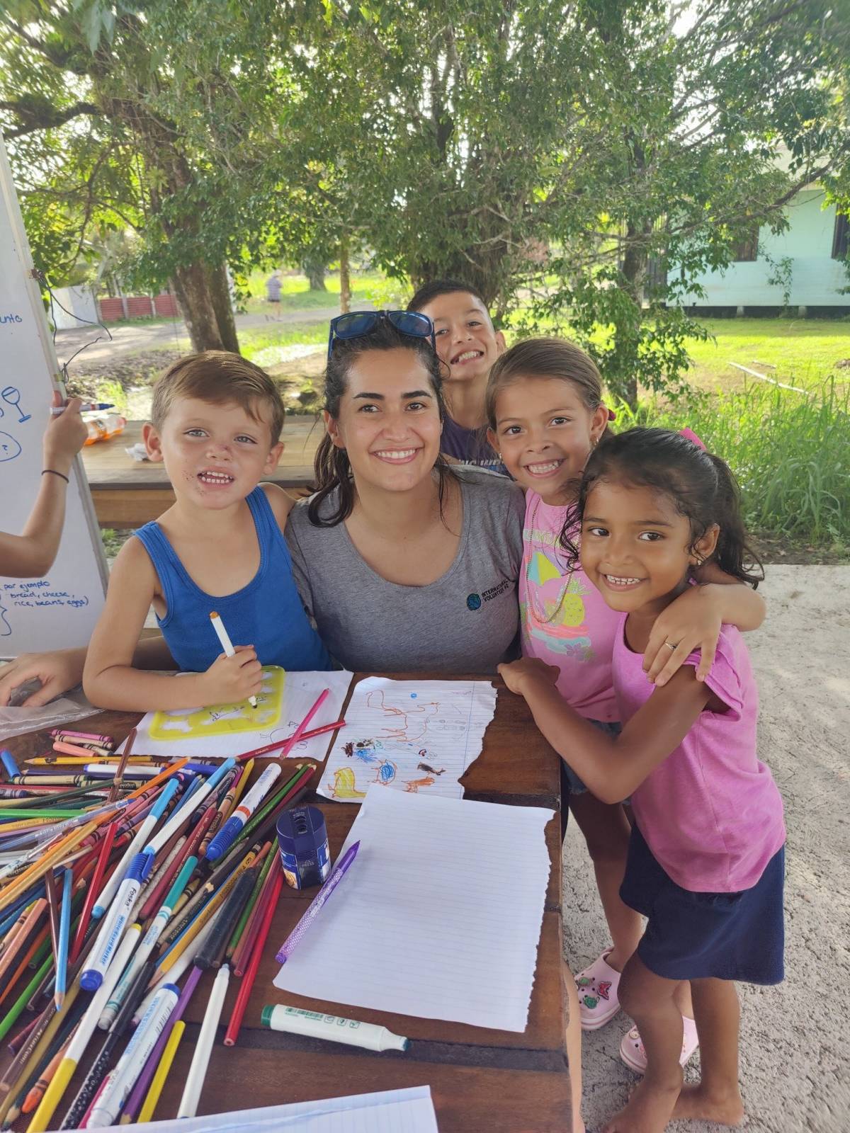 A Volunteer Coloring and Teaching English to a group of Children