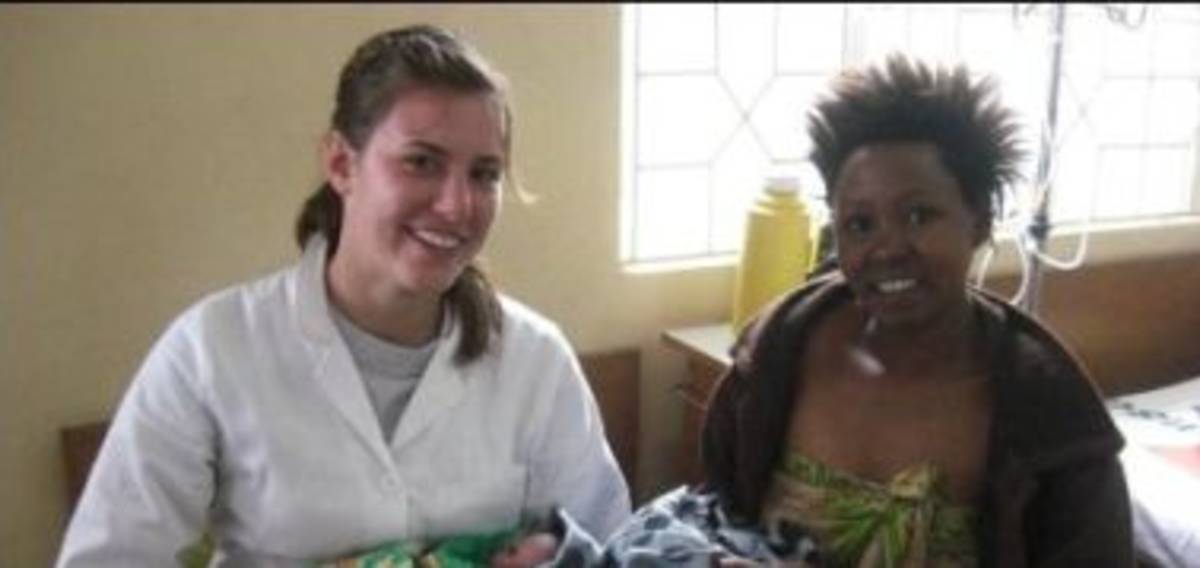 A woman holding a baby in a hospital room.