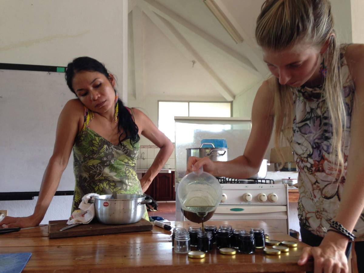 A woman pours liquid into jars. 