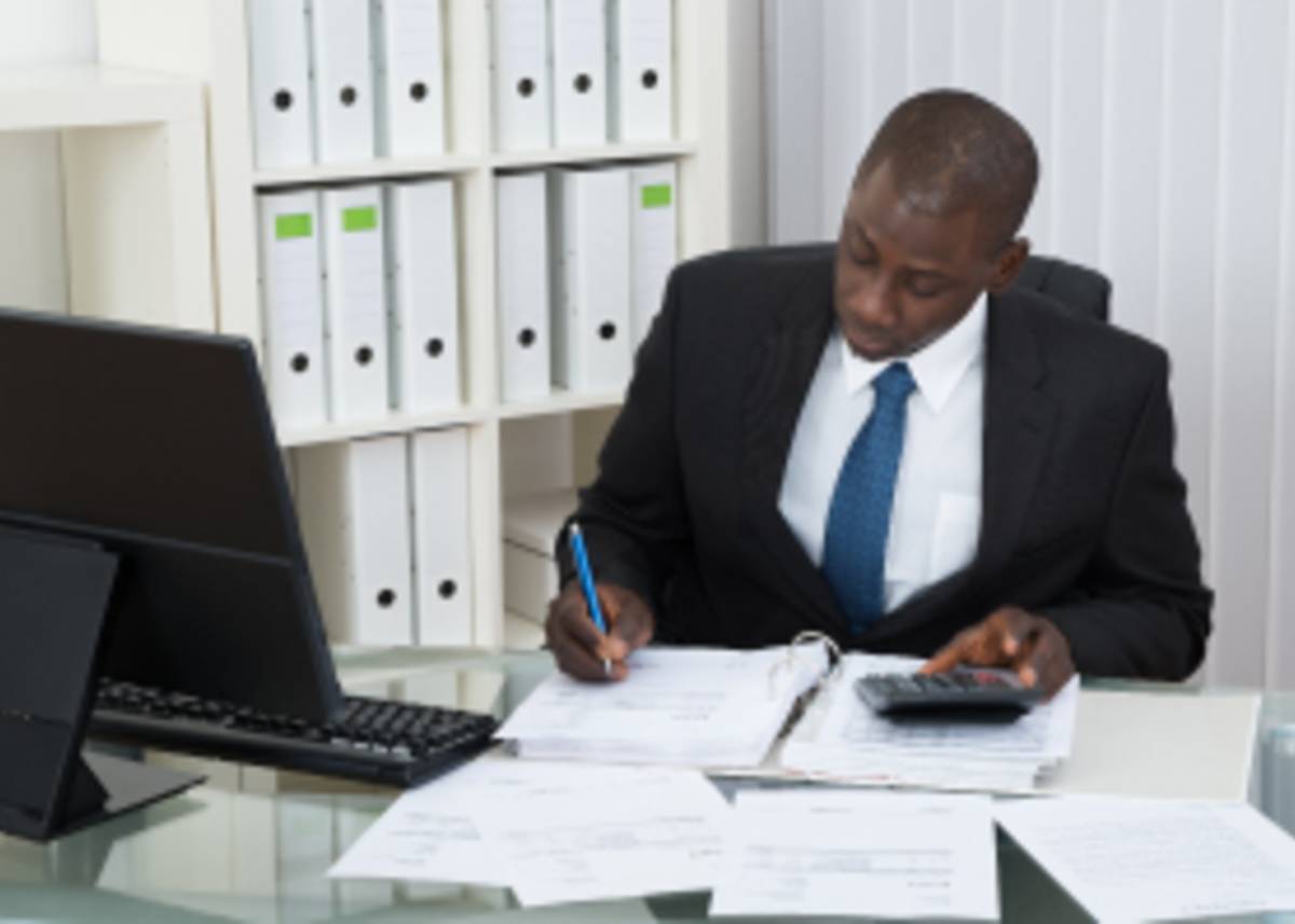 A young Accounting professional with a calculator and books