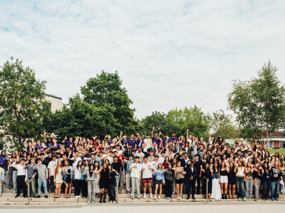 Big group photo of students on WBS steps smiling