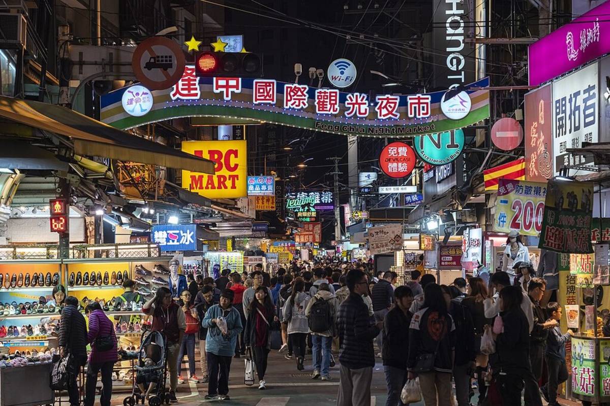 Busy night market in Taichung Taiwan with food stalls and neon lights, cultural highlight for TEFL teachers