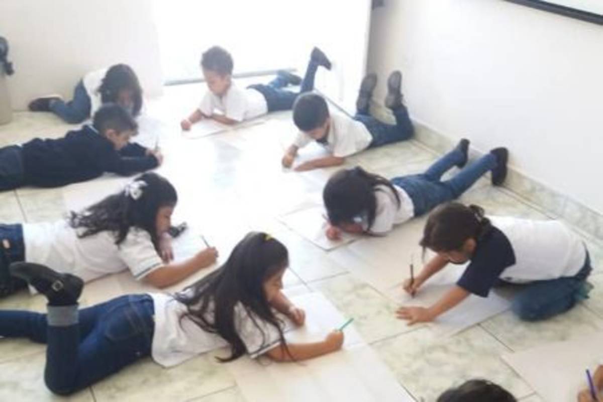 Children writing on the floor