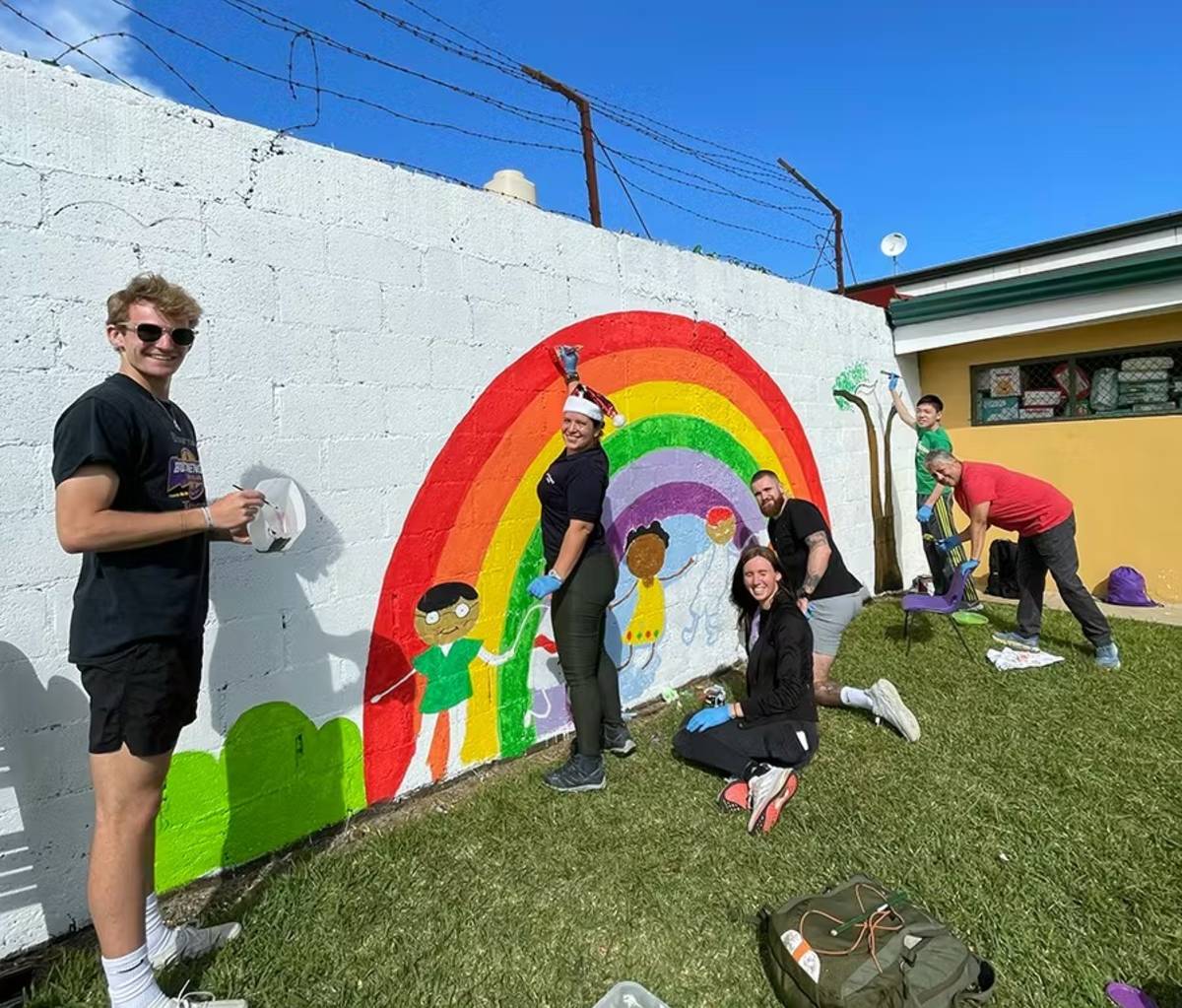 Christmas Holliday Program Volunteers Painting a Community Mural