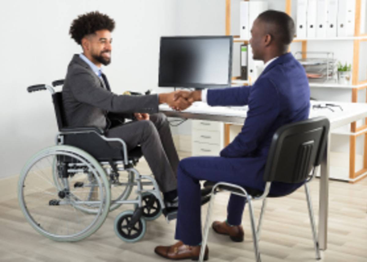 Differently-Abled man  in a wheel chair shaking a Soc. Worker's hand 