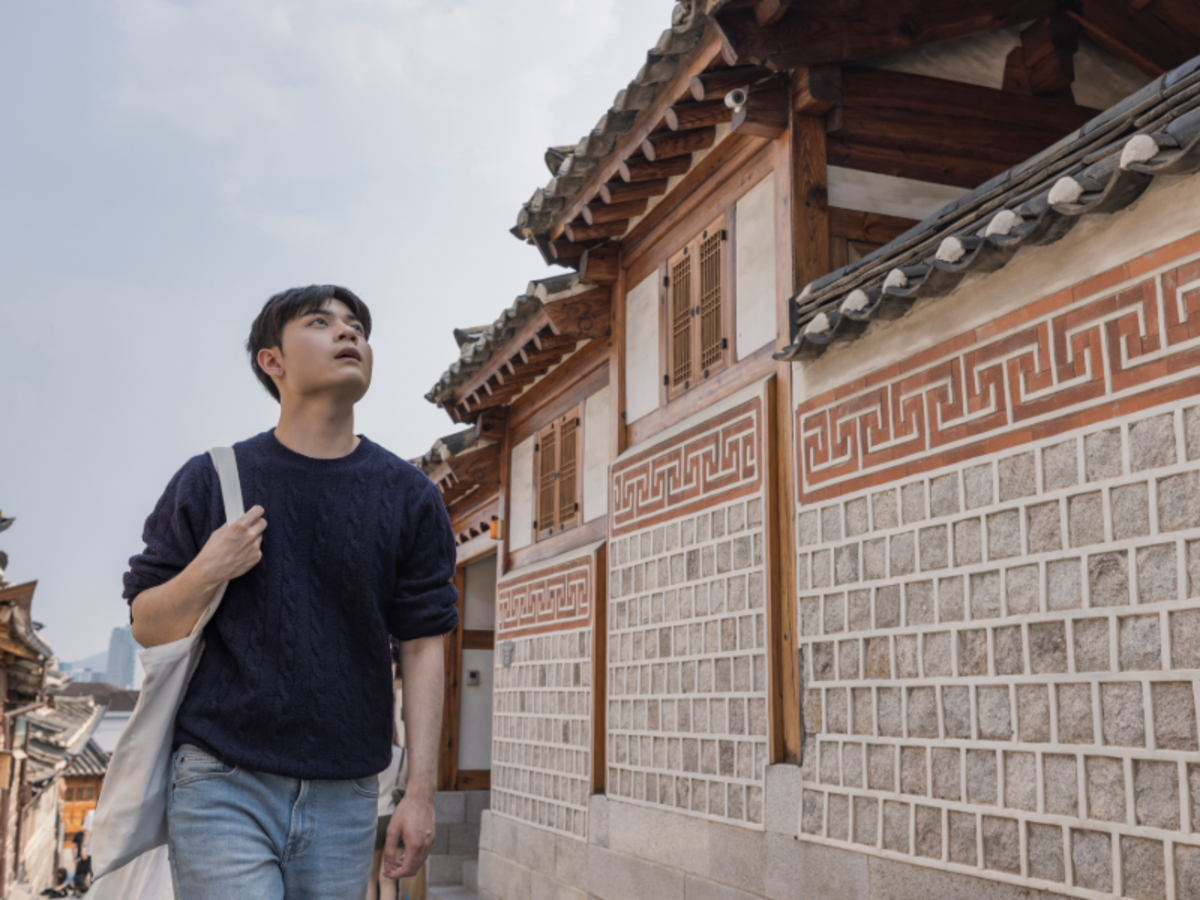 EF student walking through Bukchon Hanok Village in Seoul, surrounded by traditional Korean houses.