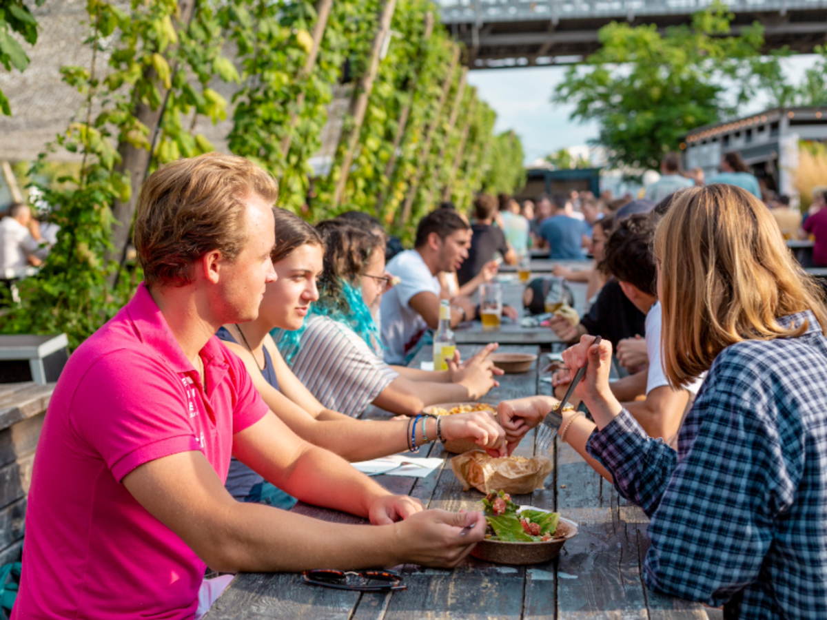 EF students in Berlin sharing a meal at a lively outdoor restaurant, enjoying food and conversation together.