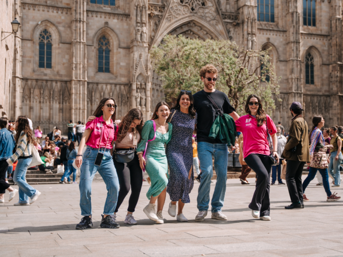EF students walking together and smiling in front of the Barcelona Cathedral in the Gothic Quarter.