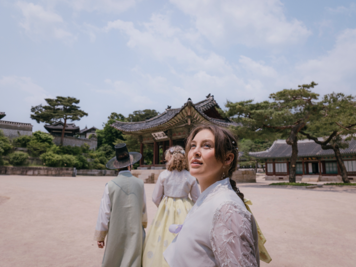 EF students wearing traditional hanbok while exploring a historic palace courtyard in Seoul.