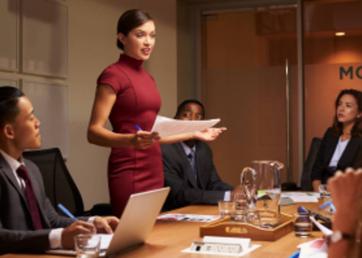 Executives in a conference room listening to a colleague pitch ideas.