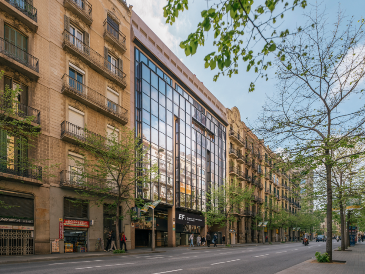 Exterior view of the EF Barcelona school building, with a modern glass façade along a busy city street.
