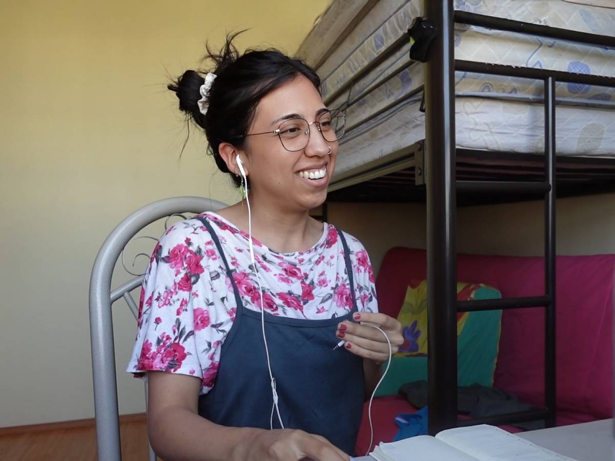 Female online TEFL teacher smiles while looking at her laptop.