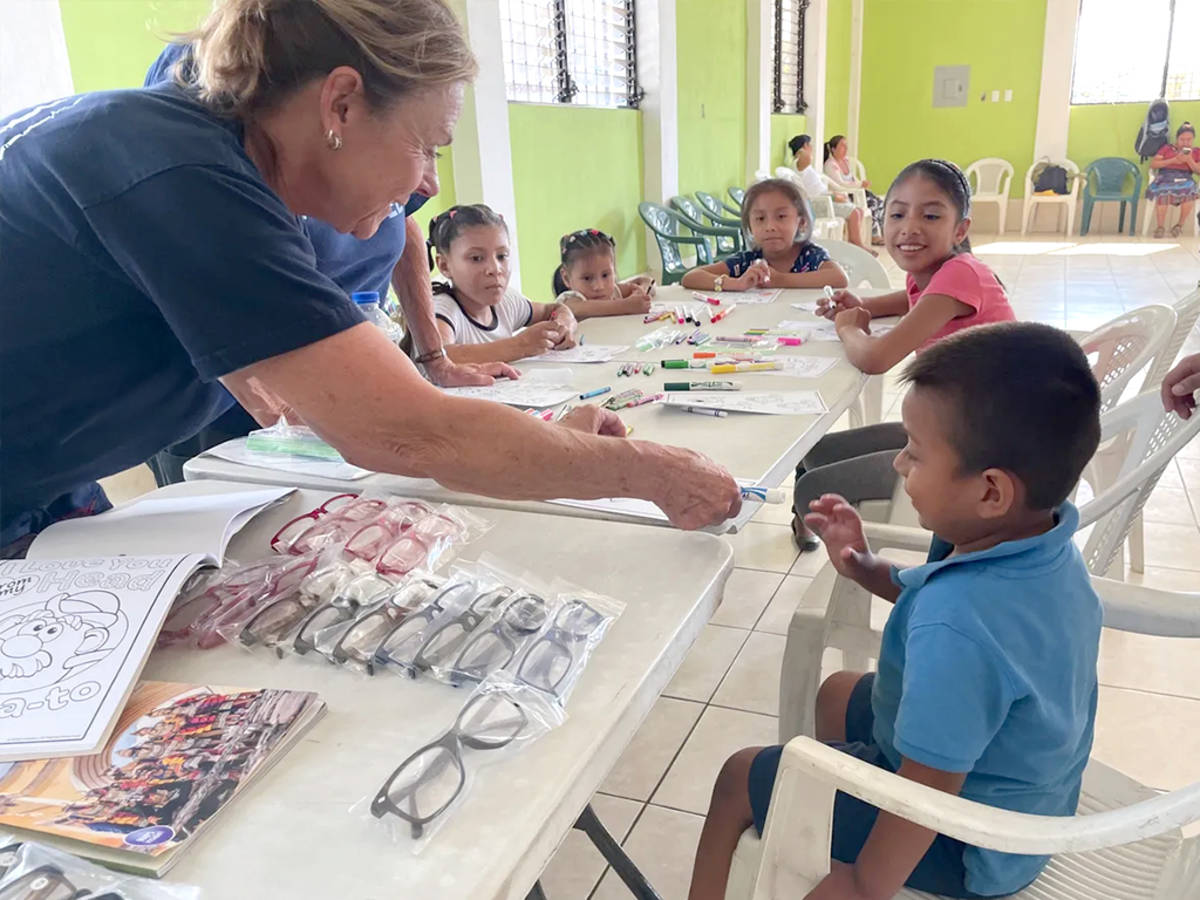 Female Volunteer Helping a Child pick out a new pair of Glasses