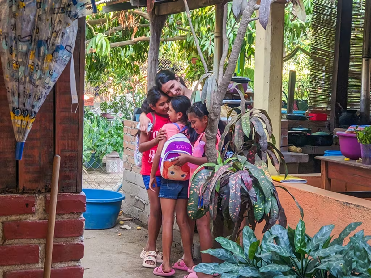 Female Volunteer Hugging Children