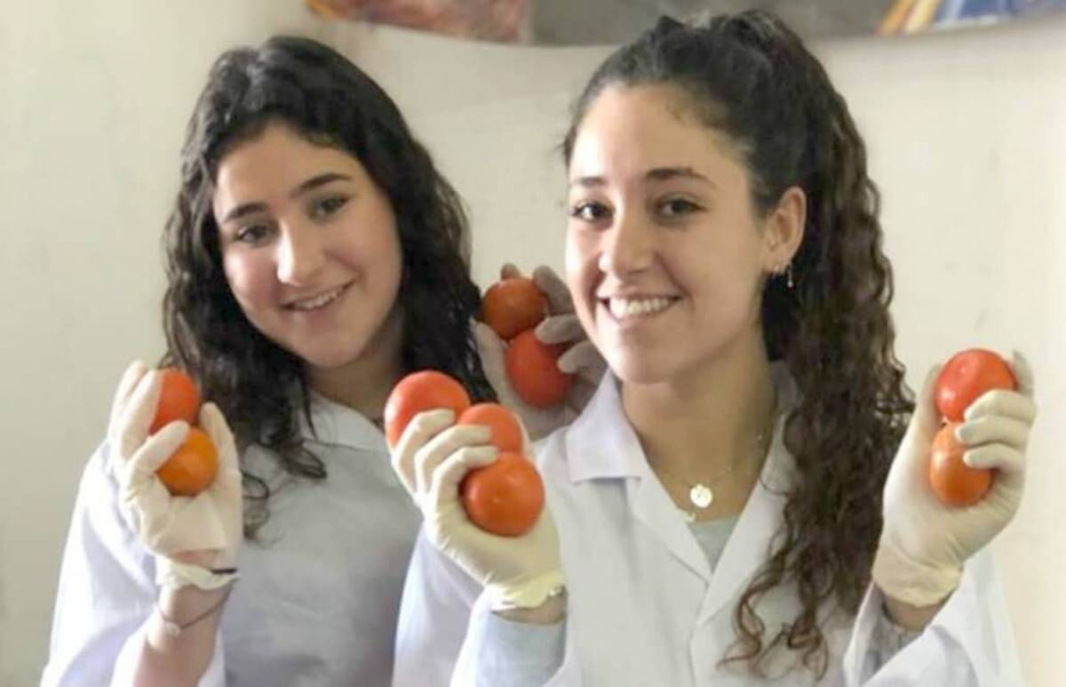 two girls holding some tomatoes