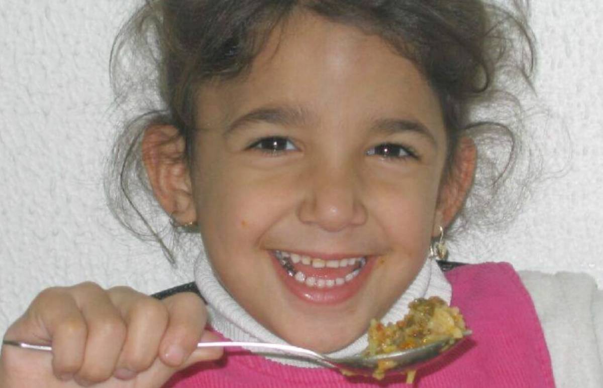 a child holding a spoonful of food