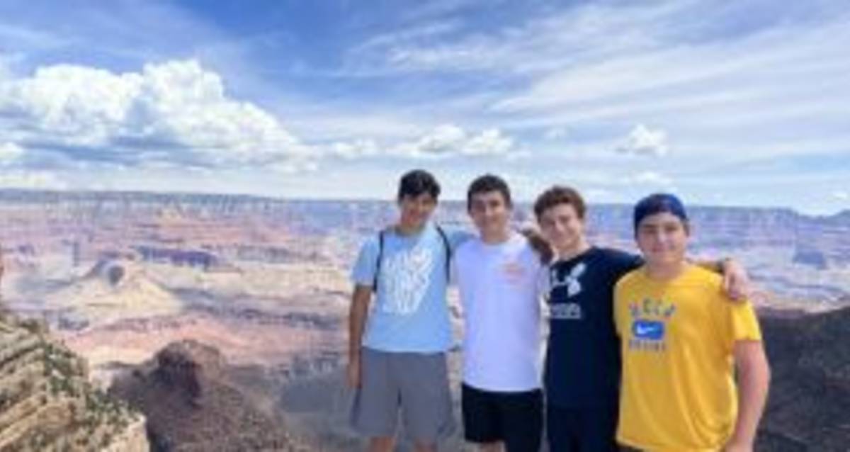 Four young men standing on a cliff