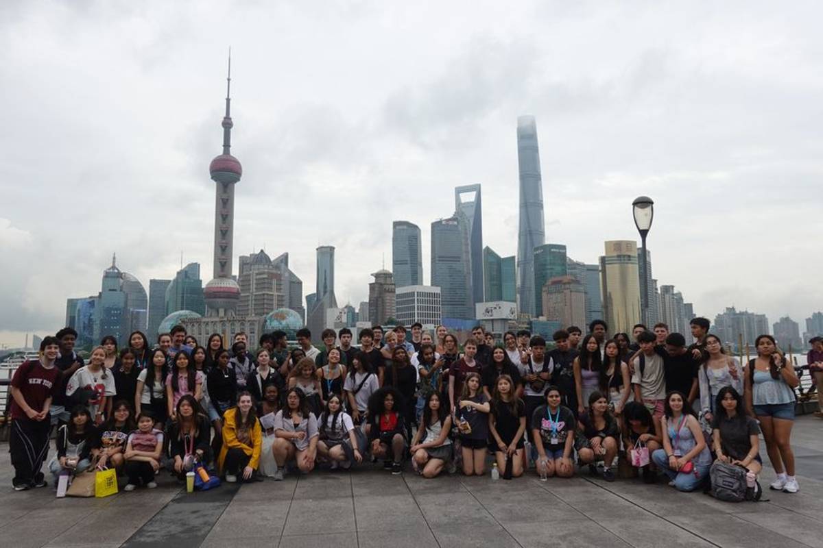 Gap students posing in Shanghai with skyline behind them