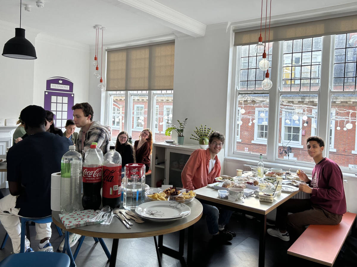 Group eating around tables and talking.
